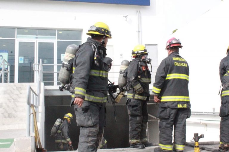 Desalojan banco al incendiarse auto en estacionamiento