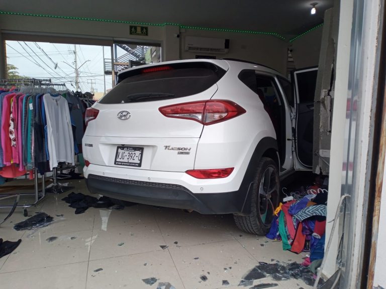 Termina camioneta en tienda de ropa tras choque; 2 heridos